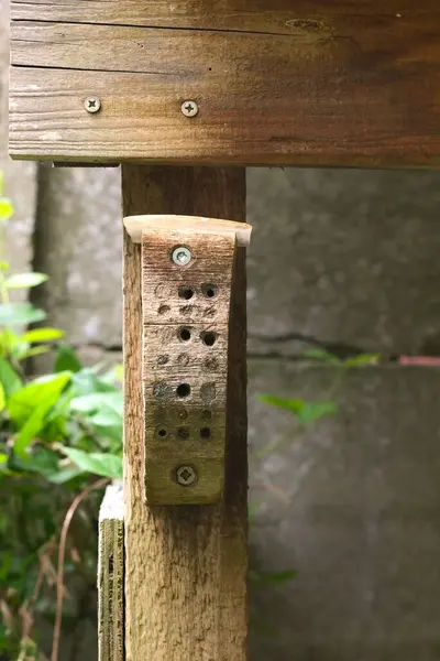 stock image DIY hotel for solitary bees, made of Robinia wood, fixed to a garden shed post.