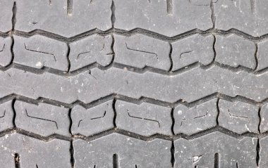 Kullanılmış bir lastiğin çizgilerine yakın, çakıl taşlarıyla çatlamış..