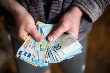 İki adamın elleri bir tomar 20 Euro 'luk banknota yayıldı.