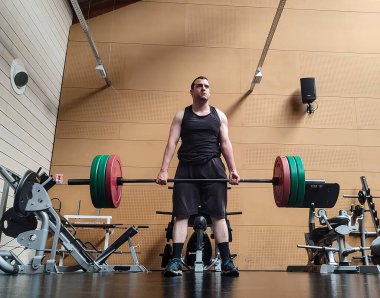 Kafkasyalı bir adamın spor salonunda kaldırma yaparken ön görüntüsü. Zihinsel hazırlık..
