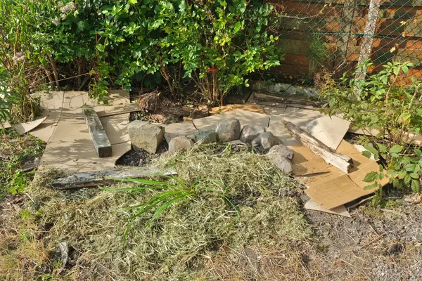 stock image Putting cardboard in a flowerbed to limit the spread of weeds and keep the soil moist. Lasagne method. Part of the area is covered with mulch.