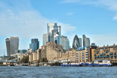 Londra, Birleşik Krallık - 11 11: 2024: Thames Nehri 'nden izlenen Gherkin ve Walkie Talkie gibi ikonik gökdelenlerin yer aldığı modern Londra gökdelenleri. Tarihi binalar, tekneler ve mavi gökyüzü.