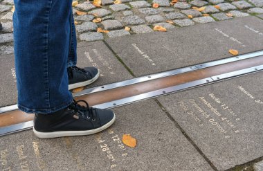 Feet straddling the Prime Meridian at Greenwich, London, with longitude markers engraved on the ground, representing global time zones. clipart