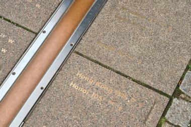 Greenwich, Londra 'da, küresel zaman dilimlerini temsil eden yere oyulmuş boylam işaretleriyle Birincil Meridyen' i gösteren çapraz kompozisyon.