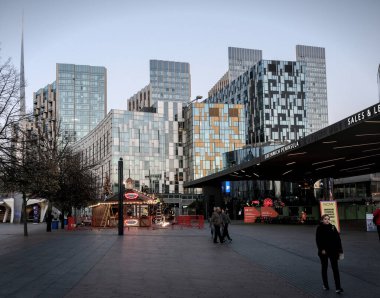 Londra, Birleşik Krallık - 11 11: 2024: Kuzey Greenwich 'te yansıtıcı cam cepheleri, bir tatil pazarı ve kentsel ağaçların yer aldığı modern binalar. Canlı şehir ortamında çağdaş mimari.