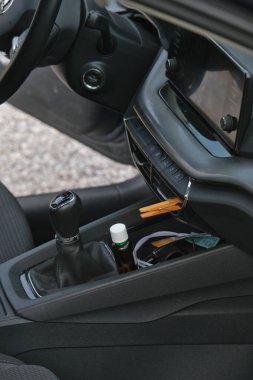 Arabanın içi manuel vites değişimi, havalandırmada manuel vites iğnesi, gerekli bir DIY yağ dağıtıcı olarak kullanılan bir mandal ve merkez konsolda bir şişe gösteriyor..