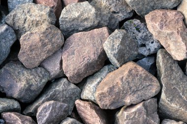 Çeşitli toprak tonlarında sert ve doğal kayalar yığını, yapı ve peyzaj teması için uygun doku ve düzensiz şekiller gösteriyor..