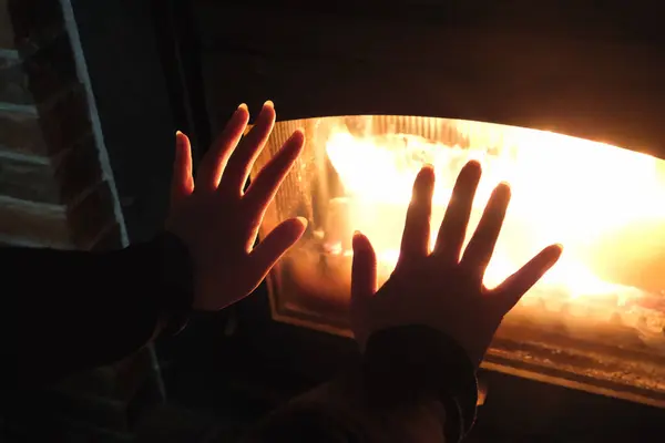 İki el, içinde alevler olan cam kaplı bir şöminenin yanında tutuluyor. Bu da sıcaklık ve rahatlığı gösteriyor. Sahne samimi ve davetkar..