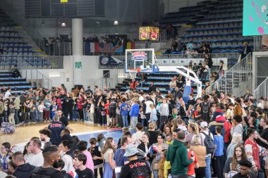 Orchies, Fransa - 03 28 2025: Harlem Globetrotters bir basketbol arenasında performans sergiliyor, atletizm, mizah ve gösteri harmanlanıyor. Kalabalık göz kamaştırıcı hileleri için tezahürat yapıyor..