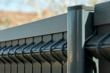 Parmaklıkları birbirine kenetlenmiş modern metal çitler ve üst demiryolu, dayanıklı yapı, güvenlik ve çağdaş tasarımı detaylı bir şekilde sergiliyor..