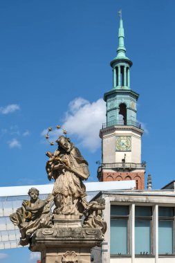 Poznan, Polonya - 04 21 2025: Nepomuk Aziz John Anıtı ve Poznan Belediye Binası saat kulesine yakın çekim.