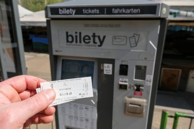 Poznan, Polonya - 04 20 2025: Güneşli bir günde Polonyalı bir toplu taşıma biletini kentsel bilet makinesinin önünde tutmak.