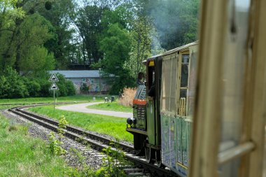 Poznan, Polonya - 04 23 2025: Poznan turistik merkezi, Maltanka buharlı treni, Malta Gölü etrafındaki manzaralı bir parkta nostaljik bir yolculuk teklif ediyor.