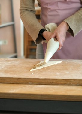 Dolu kruvasan yapma sürecinin bir parçası olan geleneksel hamur işi atölyesinde hamur hazırlıklarına yakın çekim.