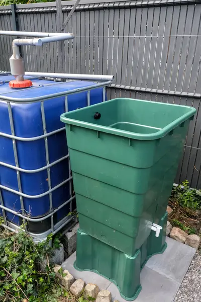 İki su tankını birbirine bağlayan yağmur suyu taşma sistemi. Yeşil tank, sürdürülebilir bahçe kullanımı için mavi kaptaki fazlalıkları topluyor.