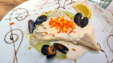 Krem soslu, midyeli, püre ve garnitürlü zarif paten tabağı, gurme deniz ürünleri sunumu için sanatsal kaplama..