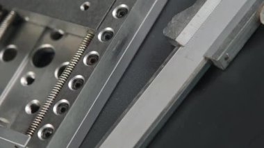 Pikabın üzerinde dönen metal parçasının yakınındaki kalibre yakın plan, mekanik hassasiyet, mühendislik konsepti ve endüstriyel detay vurgulanıyor.