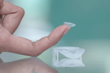 Kadın parmağında kontak lens, yakın görüş, tıbbi konsept ve vizyon.