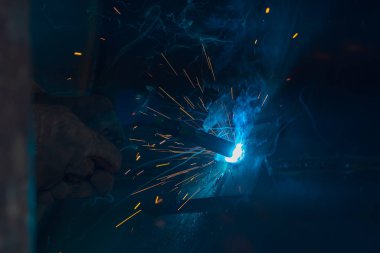 Teknik kaynakçı, teknik atölyede endüstriyel çelik kaynakçı, endüstriyel çelik kaynakçı, teknik fabrikada teknik çelik, çelik kaynaklama, kıvılcım, havai fişek gibi hafif renk.