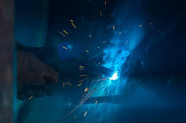 Teknik kaynakçı, teknik atölyede endüstriyel çelik kaynakçı, endüstriyel çelik kaynakçı, teknik fabrikada teknik çelik, çelik kaynaklama, kıvılcım, havai fişek gibi hafif renk.