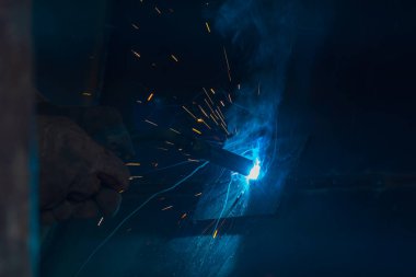 Teknik kaynakçı, teknik atölyede endüstriyel çelik kaynakçı, endüstriyel çelik kaynakçı, teknik fabrikada teknik çelik, çelik kaynaklama, kıvılcım, havai fişek gibi hafif renk.