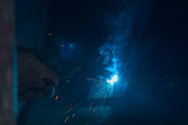 Teknik kaynakçı, teknik atölyede endüstriyel çelik kaynakçı, endüstriyel çelik kaynakçı, teknik fabrikada teknik çelik, çelik kaynaklama, kıvılcım, havai fişek gibi hafif renk.