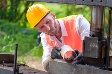 İnşaat mühendisi veya işçisinin beton temelleri için kaliteli çeliği kontrol etmesi ve inşaat alanında veya fabrikada yuvarlak barın kalitesini kontrol etmesi 