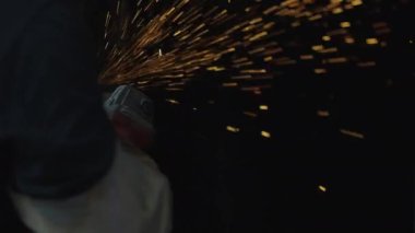 Fabrikadaki çelik yapının üzerinde elektrikli çarklar demir çerçevenin dikişlerini öğütüyor. Bu süreçte metalden parlak kıvılcımlar çıkıyor.