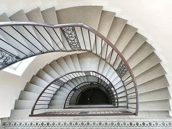 Spiral staircase leading to apartments, with beautiful pastel colors. Budapest.