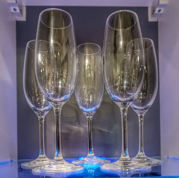 Transparent glass glasses on shelf.