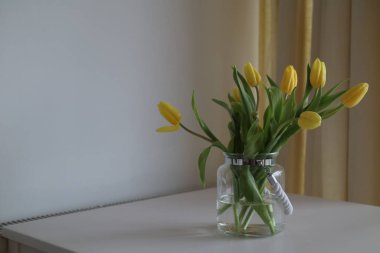 Masanın üzerinde bir buket sarı lale..