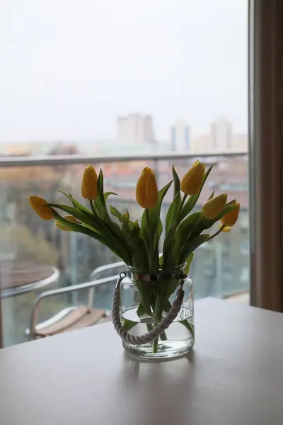 Masanın üzerinde bir buket sarı lale..