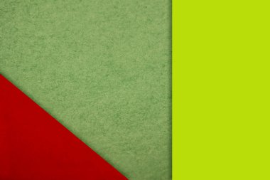 Yeşil arkaplan üzerine renkli bir kağıdın yaratıcı düzeni 