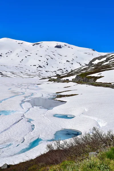 Donmuş kar, açık güneşli yaz gününde Norveç, Avrupa 'nın buzul fiyort gölünü kapladı.