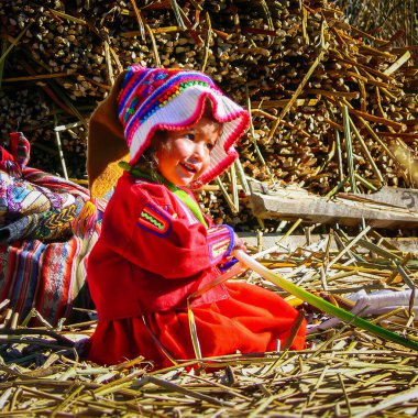 Yüzen Uros Adaları 'ndaki mutlu küçük kız, Titicaca Gölü Peru