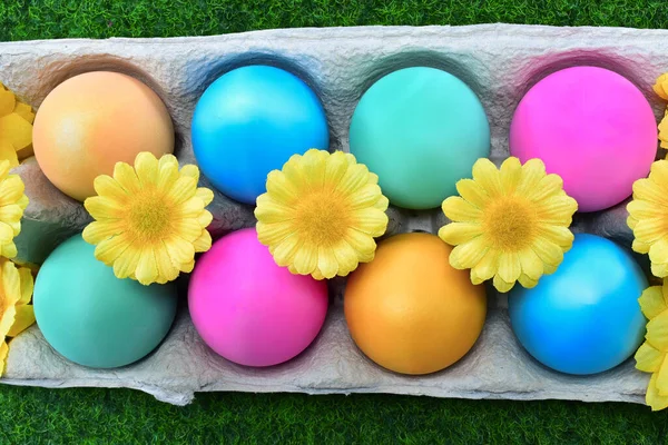 Parlak renkli Paskalya yumurtaları, sarı çiçekli süslemeler, yukarıdan görünen üstten.. 