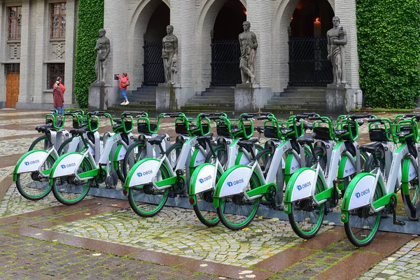 Yeşil elektrikli bisiklet parketmiş ve bisiklet paylaşım istasyonunda şarj olmuş. Ekolojik ulaşım araçları. Bergen, Norveç, İskandinavya, Avrupa.