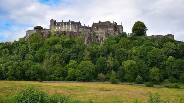 Stirling, Birleşik Krallık - 5 Temmuz 2023: Stirling kalesi volkanik kayalar üzerinde yüksek alan ve ormanın üzerinde, arka duvar panoramik manzarası. İskoçya, İngiltere, Avrupa.