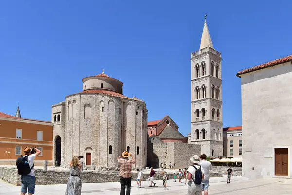 Zadar, Hırvatistan - 28 Haziran 2024: Antik Roma forumunda St. Donatus kilisesi ve St. Anastasia çan kulesinin fotoğraflarını çeken turistler, Zadar Eski Kasabası 'nı, tarihi Hırvatistan' ı ve Avrupa 'yı ziyaret ettiler