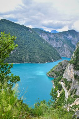 Road and tunnel by the lake in vast mountain landscape, view from above. Montenegro nature, explore the Balkans, travel Europe clipart