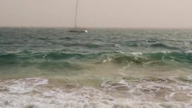 Dalgalar dönüyor, tekneler denizde sallanıyor. Kanarya Adaları 'nda Calima (sahara tozu) hava durumu.