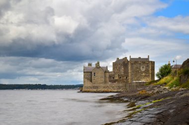 Suyun kenarından Karanlık Kale 'nin manzarası, uzun pozlama yumuşak, pürüzsüz su yaratır. İskoçya 'yı keşfetmek, Birleşik Krallık' ı keşfetmek, Avrupa 'yı gezmek.