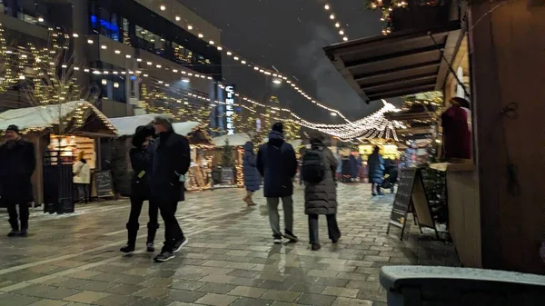 night view on people with shopping cart in city