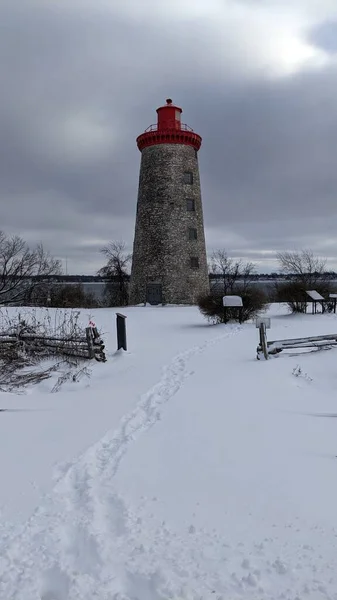 the old lighthouse on the shore in the winter