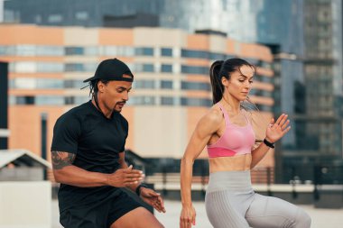 Genç sporcular çatıda ısınma egzersizleri yapıyorlar.