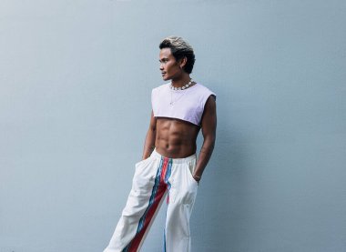 Gri duvarda duran şık adam.