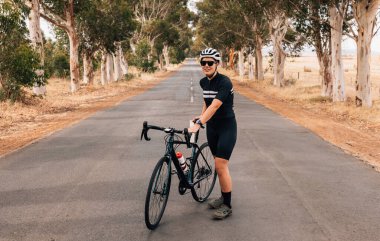 Bisikletli bir kadın gezinti sırasında kırsalda durup dinleniyor.