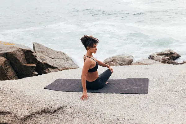 Kadın yoga eğitiminden önce vücudunu ısıtmaya çalışıyor.