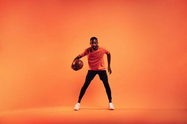 Basketbol oynayan bir sporcu. Stüdyoda basketbol oynayan genç bir erkek..