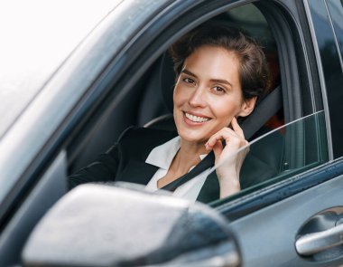Beautiful business lady looking at camera. Young woman looking out of the window.	